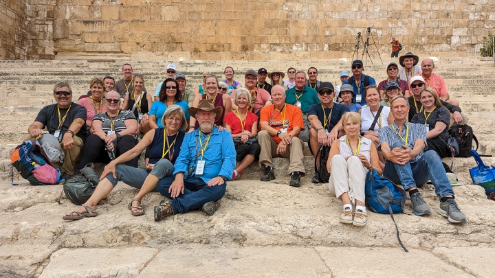 a group of people sitting on the steps on a historical site