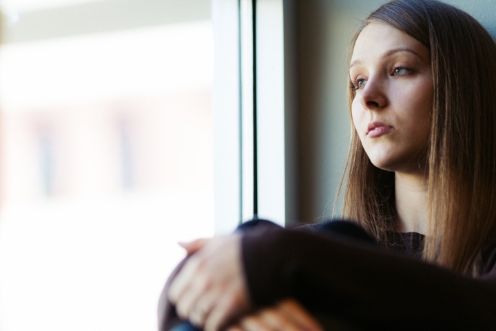 A young woman sitting by herself.