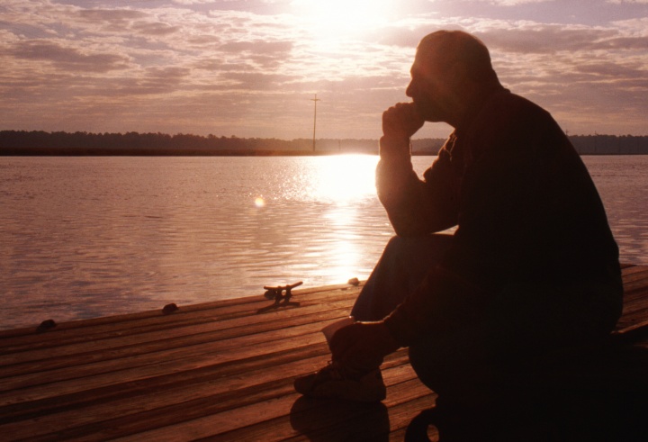 A older man sitting and thinking. 