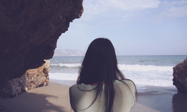 A woman looking at the ocean.