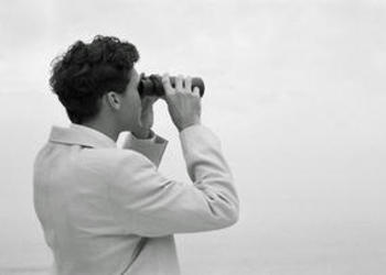 A man looking through binoculars.