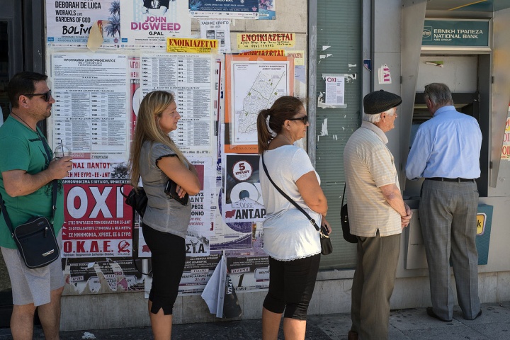 People waiting in line in to use a bank ATM.