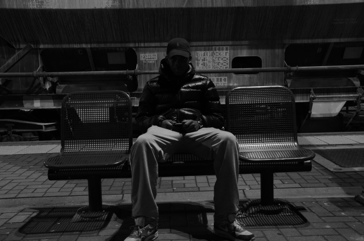 A person sitting along on a bench.