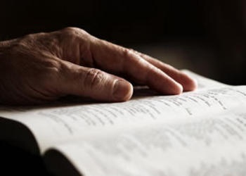 Hand on top of a Bible