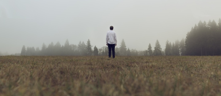 A man standing by himself in an open field.