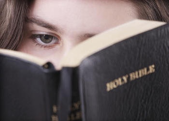 A teen girl reading her Bible.