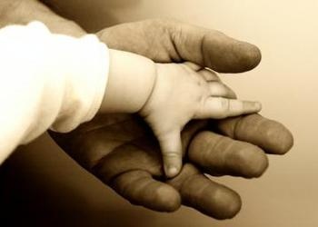 Baby hand on top of a big hand - God's Family: The Reason You Were Born 