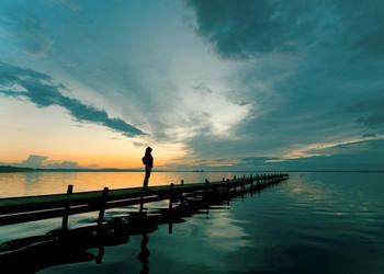 A woman on a dock looking up to the sky.