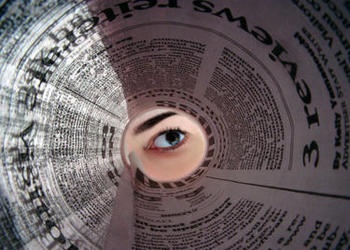 looking through a rolled newspaper
