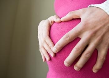 Woman holding her pregnant belly.