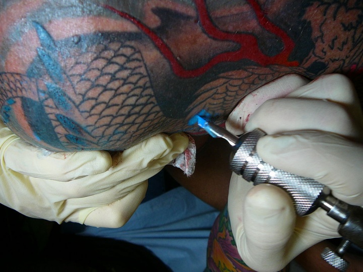 Tattooing a design on a person's arm.