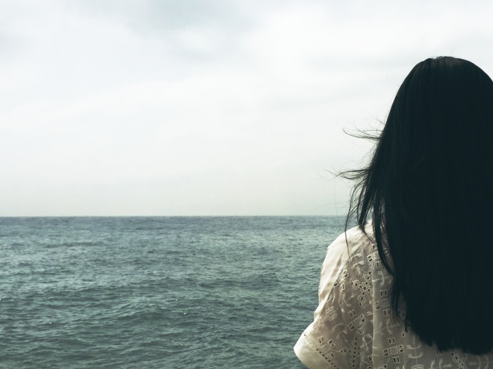 A woman looking at a body of water.