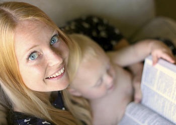 A young mother holding a Bible and reading the Bible.
