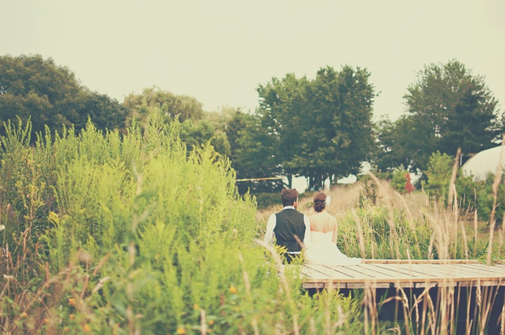 Married couple - man and woman - sitting on a dock.