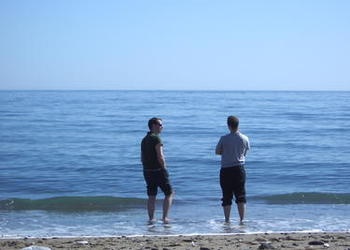 two friends talking as they look at the ocean