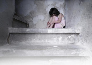 A little girl sitting on a concrete step.