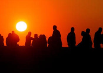 A group of people watchingthe sunset.