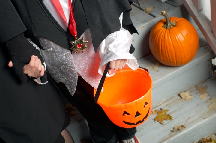 A little boy trick or treating with his mother.