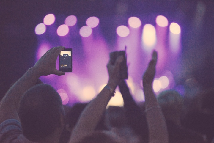 A man recording concert on his smartphone.