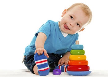 A baby playing with a stacking ring toy - Rock-a-stack