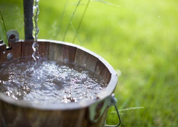 Water pouring into a wood bucket.