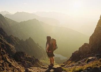 A person a top of a mountain peak.