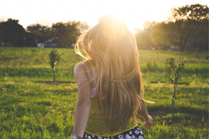 A young woman running in a field.