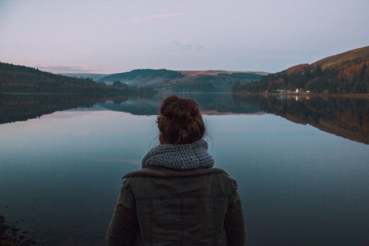 A young woman looking over a lake.