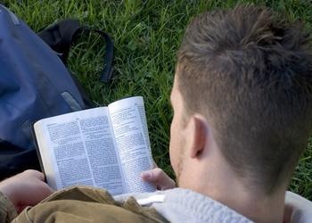 Young man reading a Bible.