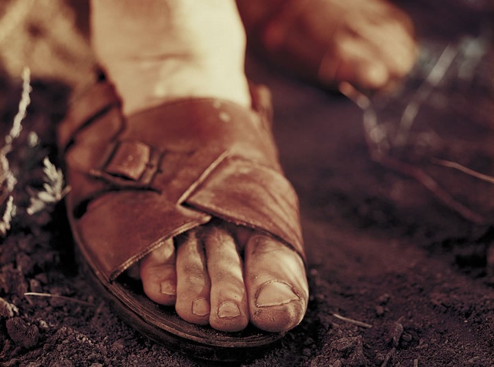 Dirty feet inside a pair of old sandals. 