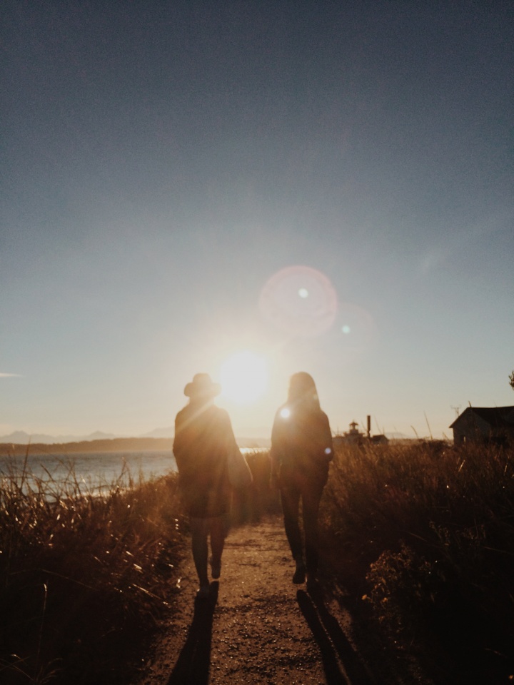 Two women walking toward a beach.