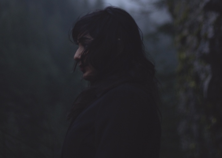 Dark clouds in the sky above a woman.