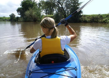 A woman paddling a kayak.
