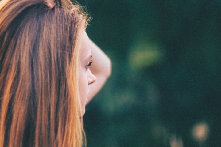 A woman looking with hand her hand by her head.