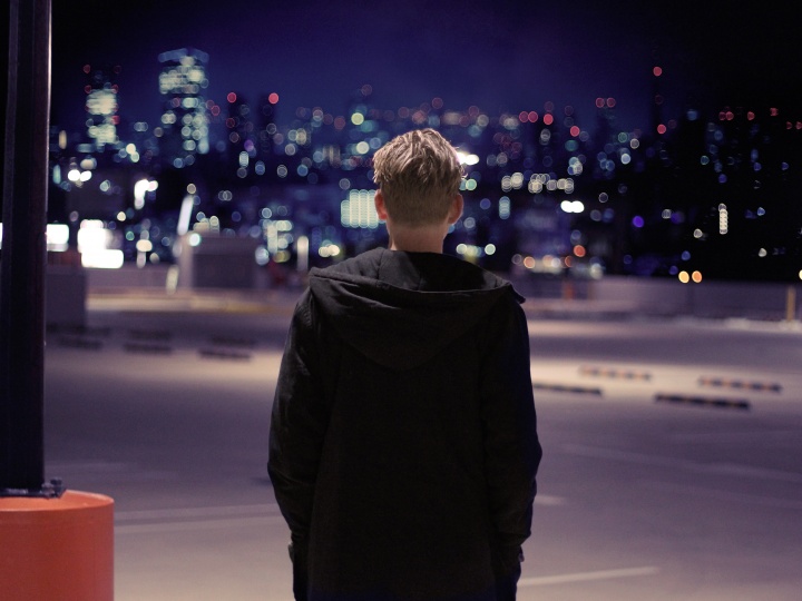 A person walking in a dark parking lot.