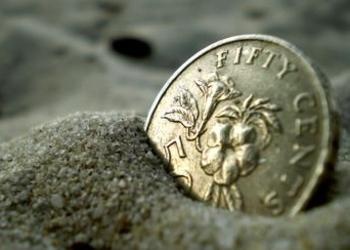 coin buried in sand