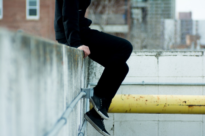 A person sitting on a concrete ledge.