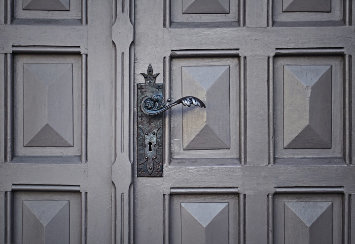 Old door with ornate handle and key hole.