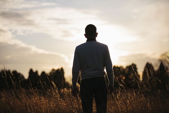 A man looking at the setting sun.