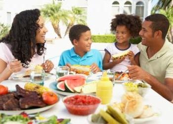 Parents and children around table with BBQ food - What Happened to the Family Me