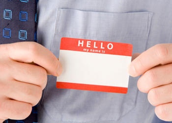 A man holding a Hello..My name is sticker badge.