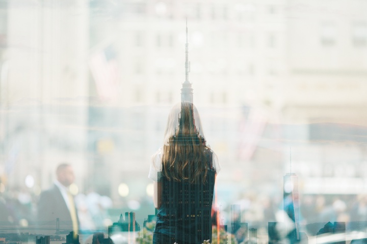 A woman's silhouette over a city building scape.