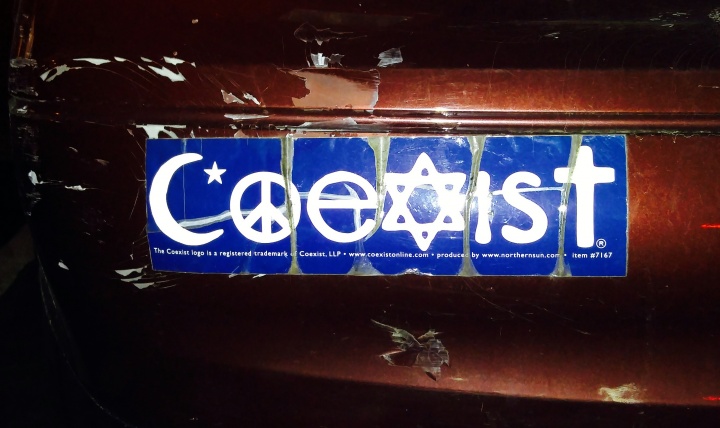 A coexist sticker on the bumper of a car.