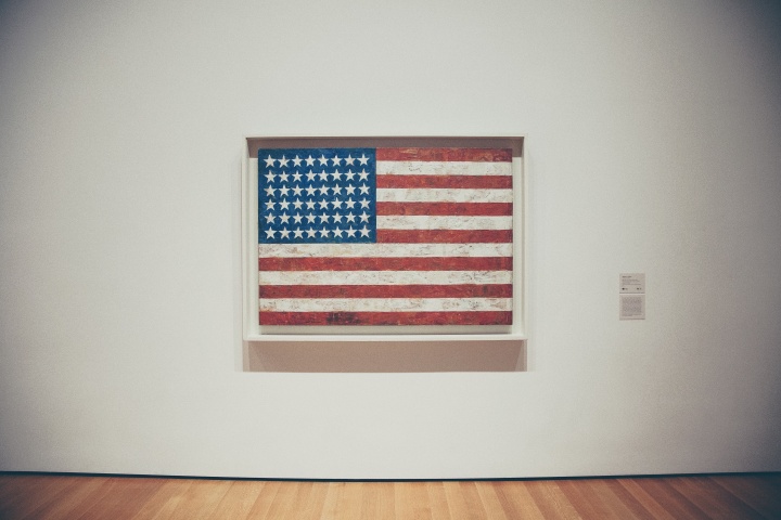 A framed old American flag hanging on a museum wall.