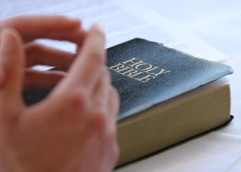 Hand on top of a Bible.