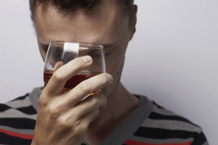 A person holding a glass of alcohol. 
