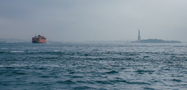 The Statue of Liberty in the distance from the ocean.