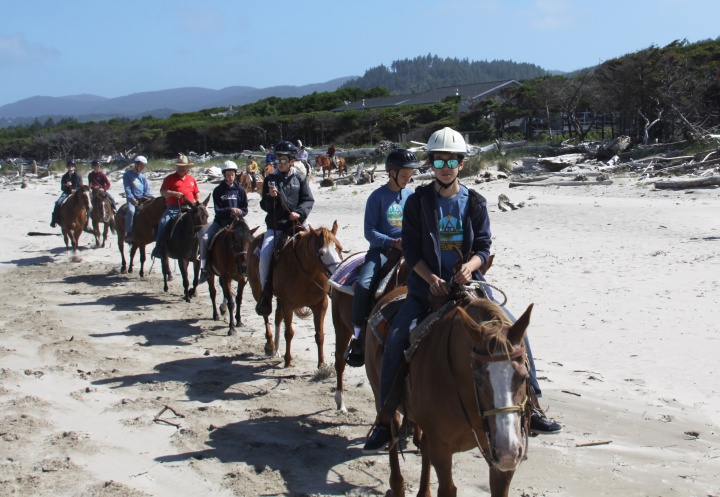 Campers riding horses on the beach at Northwest teen Camp. 