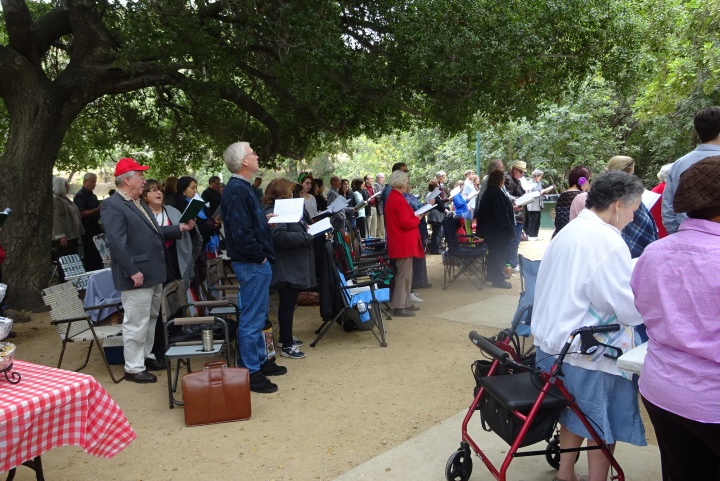 Church members sing hymns at services in the park. 