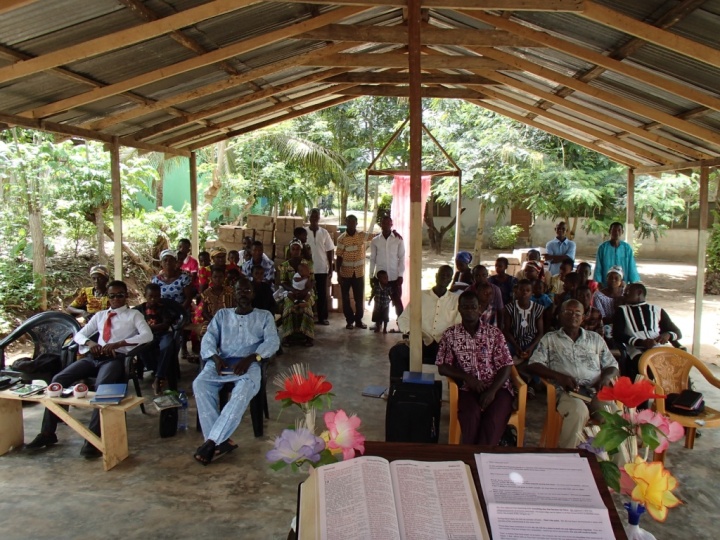 Brethen in Kwanyako, Ghana at the current meeting location. Located under low power lines, this open air structure has been condemned by the local government.